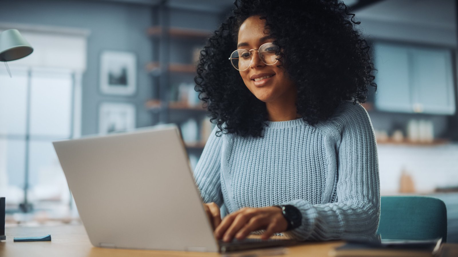 Mulher negra sentada trabalhando em um notebook